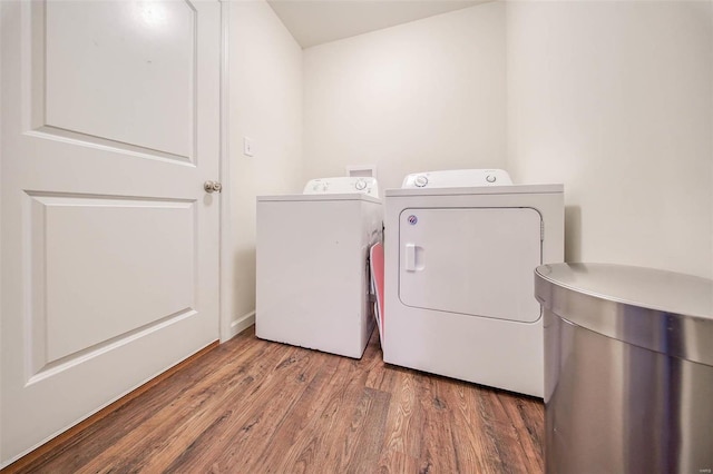 clothes washing area featuring wood-type flooring and separate washer and dryer