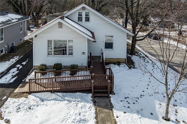 snow covered property with central AC and a deck