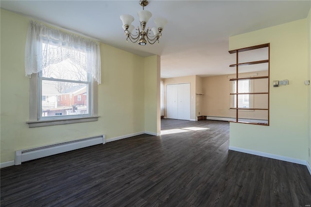 unfurnished room featuring a baseboard heating unit, a chandelier, and dark hardwood / wood-style flooring