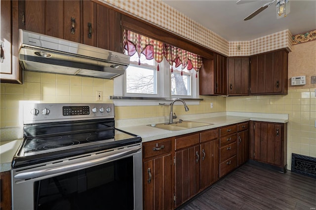 kitchen with sink, ceiling fan, electric range, dark brown cabinets, and dark hardwood / wood-style floors