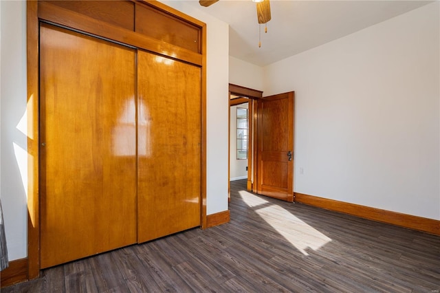 unfurnished bedroom featuring dark wood-type flooring, ceiling fan, and a closet