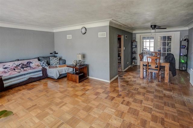 living room with ceiling fan, a textured ceiling, and parquet floors