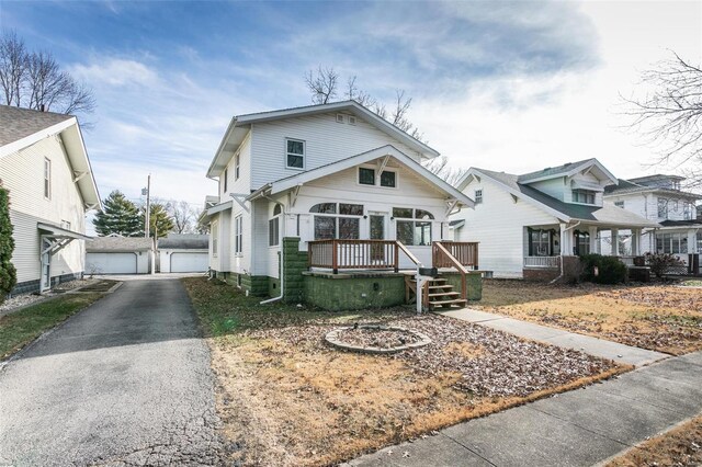 view of front of home featuring an outbuilding, a garage, and a deck