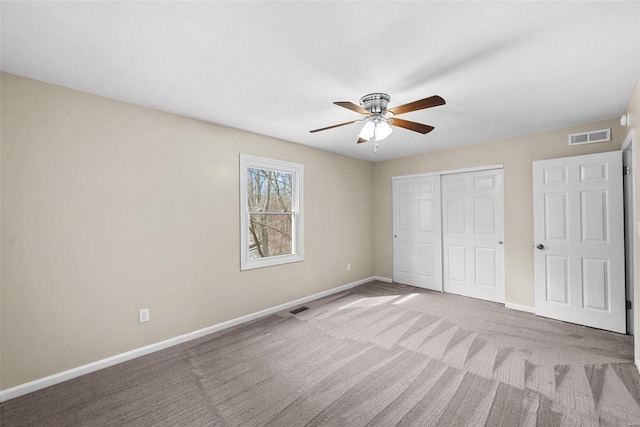 unfurnished bedroom featuring a closet, carpet flooring, visible vents, and baseboards