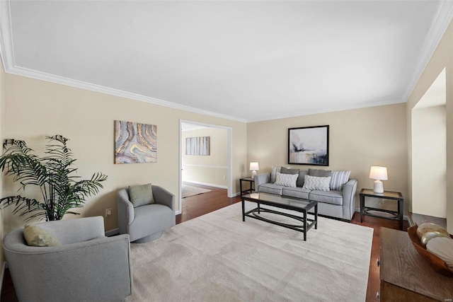 living area featuring baseboards, wood finished floors, and crown molding