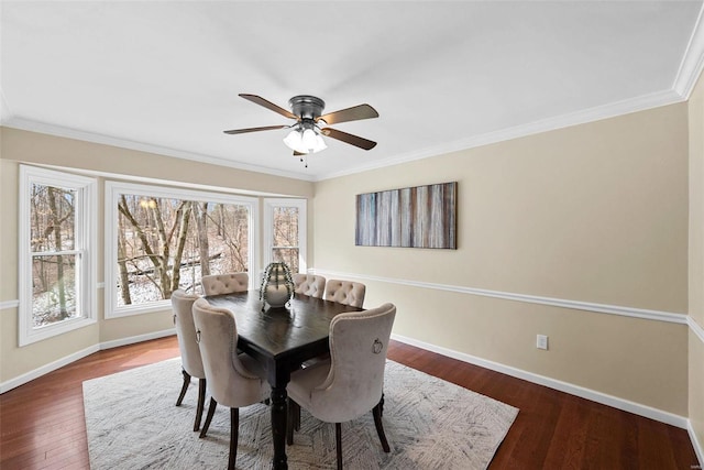 dining room featuring crown molding, ceiling fan, wood-type flooring, and baseboards