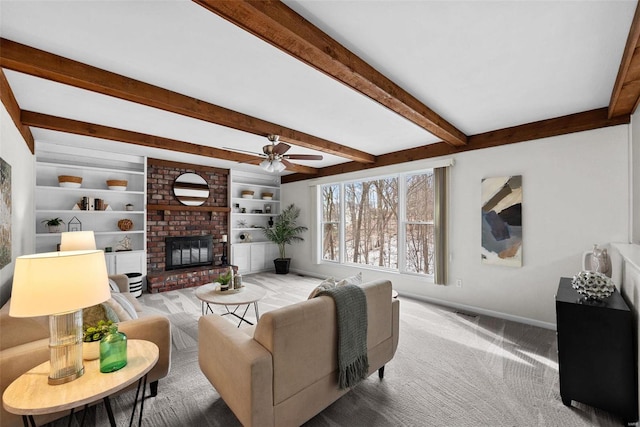 carpeted living area featuring baseboards, ceiling fan, built in shelves, a fireplace, and beam ceiling