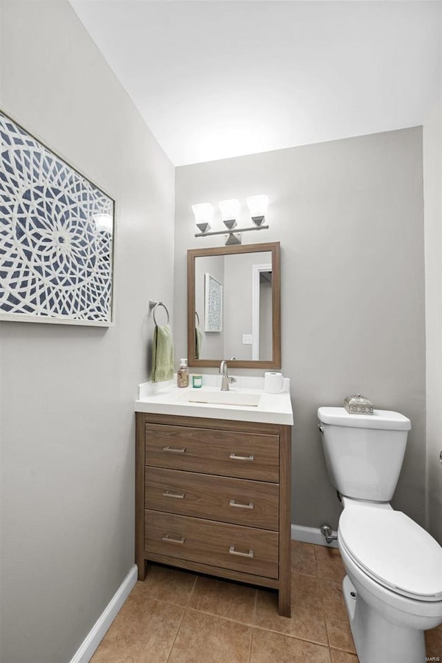 bathroom featuring toilet, baseboards, vanity, and tile patterned floors