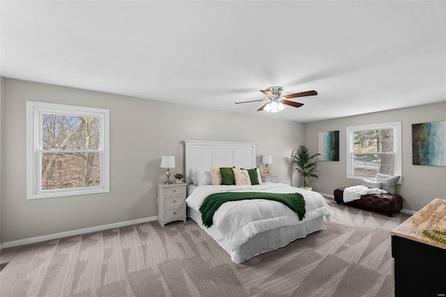 bedroom with light colored carpet, ceiling fan, and baseboards