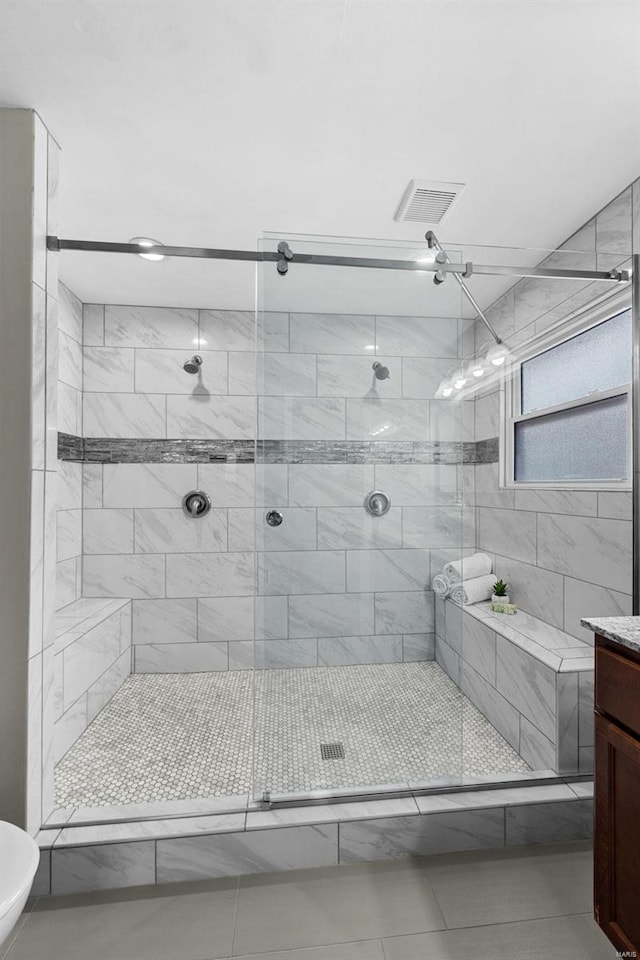 bathroom featuring visible vents, a shower stall, and vanity