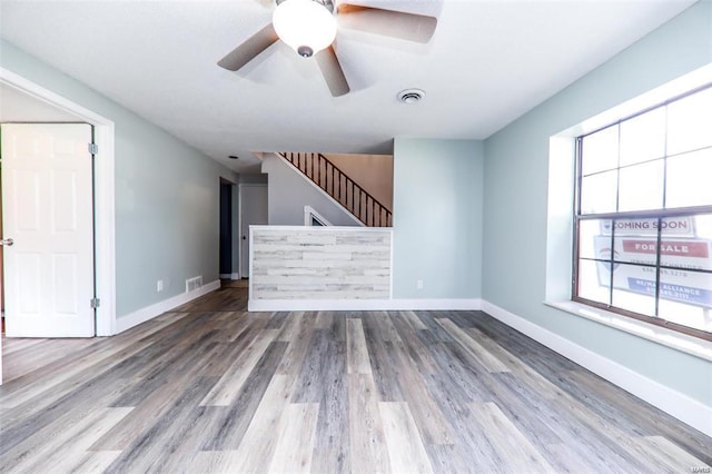 unfurnished living room with ceiling fan and hardwood / wood-style floors