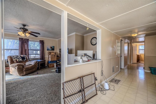 living room featuring ceiling fan, crown molding, and a textured ceiling