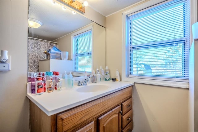 bathroom featuring crown molding, plenty of natural light, a textured ceiling, and vanity