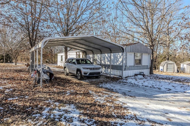 snow covered parking area featuring a carport