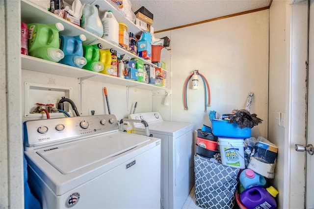 washroom featuring a textured ceiling, ornamental molding, and washing machine and dryer