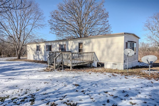 snow covered property featuring a wooden deck