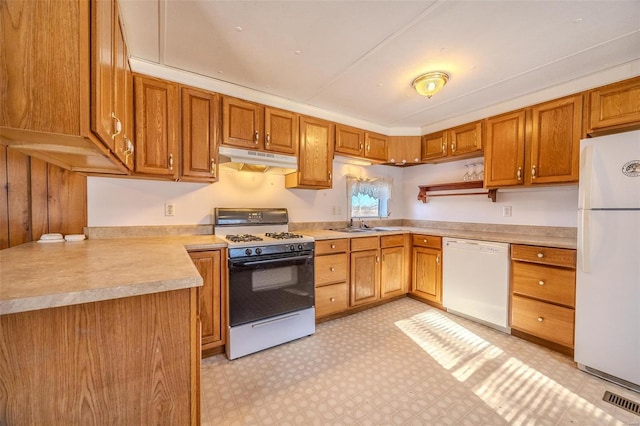 kitchen featuring sink, white appliances, and kitchen peninsula