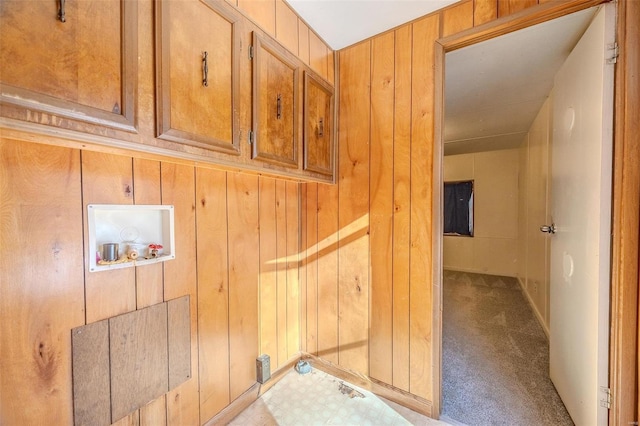 washroom featuring washer hookup, light carpet, and wooden walls