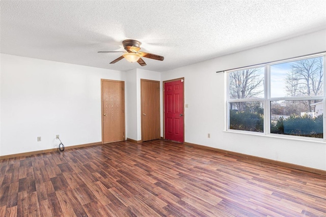 spare room with ceiling fan, dark wood-type flooring, and a textured ceiling