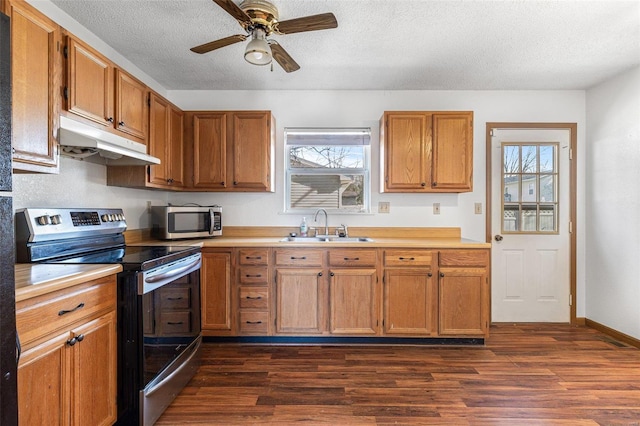 kitchen featuring stainless steel appliances, sink, dark wood-type flooring, and a textured ceiling