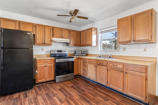 kitchen featuring appliances with stainless steel finishes, sink, dark hardwood / wood-style flooring, ceiling fan, and a textured ceiling