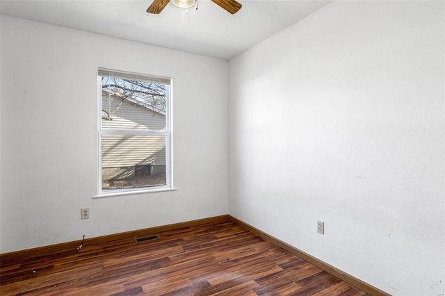 unfurnished room featuring dark wood-type flooring and ceiling fan