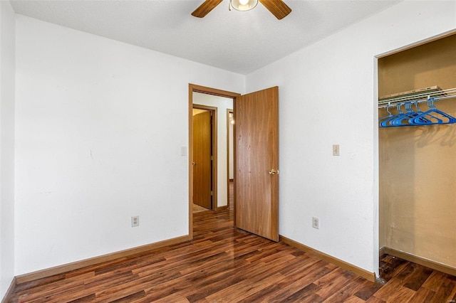 unfurnished bedroom with a textured ceiling, dark wood-type flooring, a closet, and ceiling fan