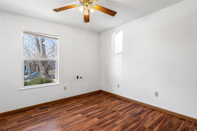 empty room with ceiling fan, dark hardwood / wood-style floors, and a textured ceiling