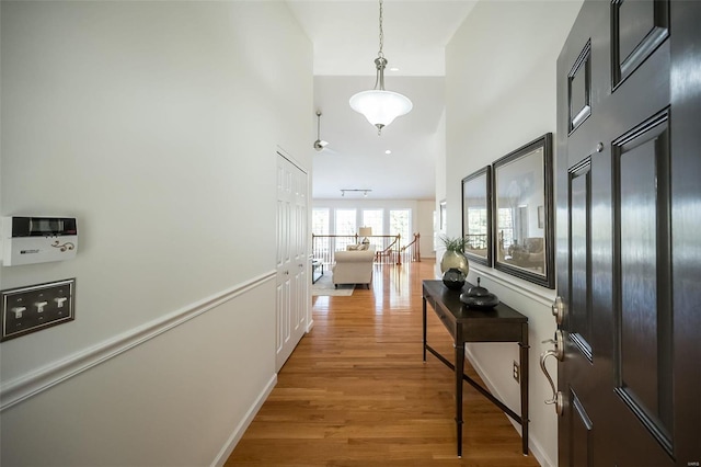 hall featuring a high ceiling and light wood-type flooring