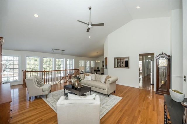 living room with light hardwood / wood-style flooring, high vaulted ceiling, ceiling fan, and track lighting