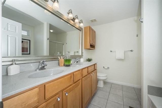 bathroom with vanity, tile patterned floors, toilet, and walk in shower