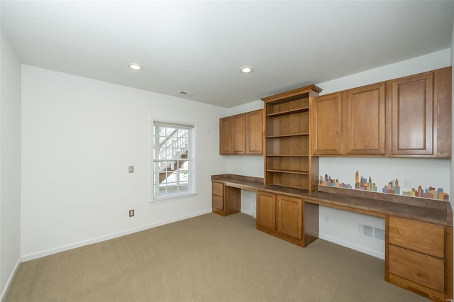 unfurnished office with built in desk and light colored carpet