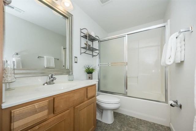 full bathroom featuring bath / shower combo with glass door, vanity, and toilet