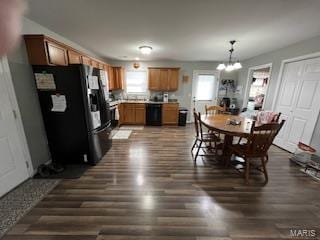 dining area featuring dark wood-type flooring and an inviting chandelier