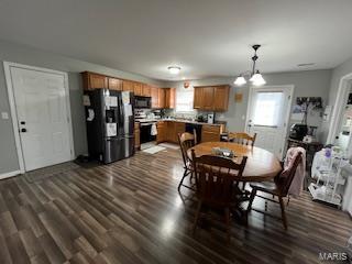 dining area featuring dark hardwood / wood-style flooring and an inviting chandelier