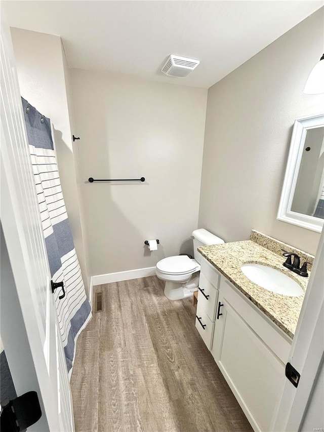 bathroom with visible vents, vanity, toilet, and wood finished floors