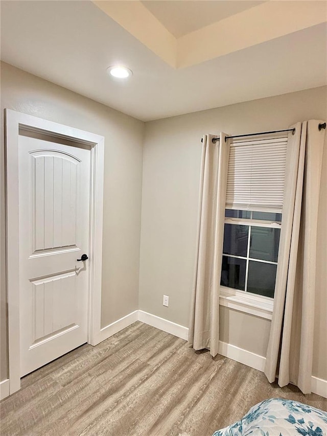 unfurnished bedroom with light wood-type flooring, baseboards, and recessed lighting