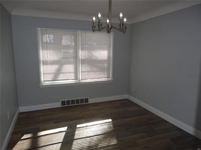 unfurnished room featuring dark hardwood / wood-style flooring and a notable chandelier