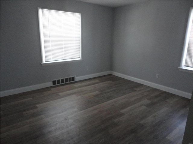 empty room with dark hardwood / wood-style flooring