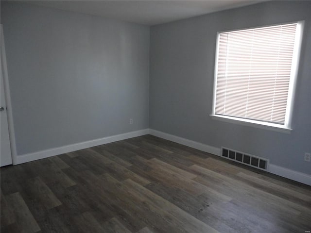 unfurnished room with dark wood-type flooring and plenty of natural light