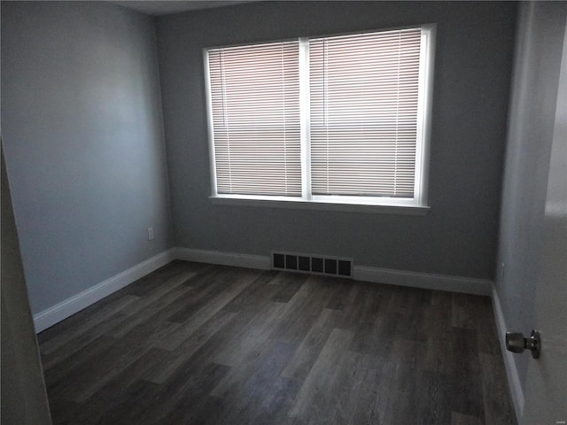 unfurnished room with a wealth of natural light and dark hardwood / wood-style floors