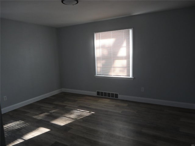 unfurnished room with dark wood-type flooring