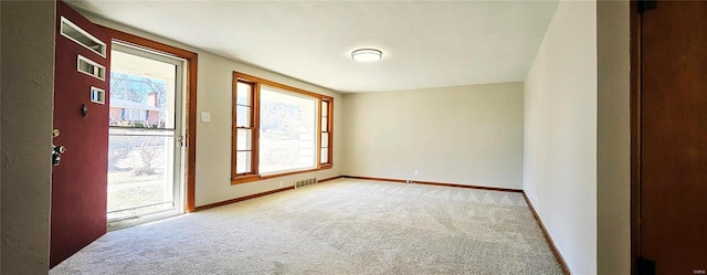 unfurnished room featuring baseboards, visible vents, and carpet flooring