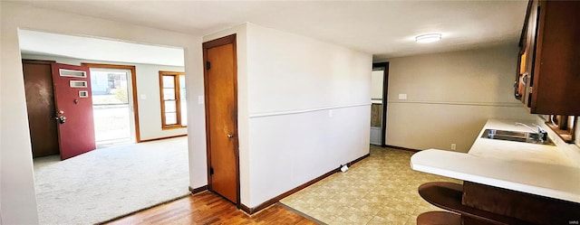 kitchen featuring light countertops, a sink, and baseboards