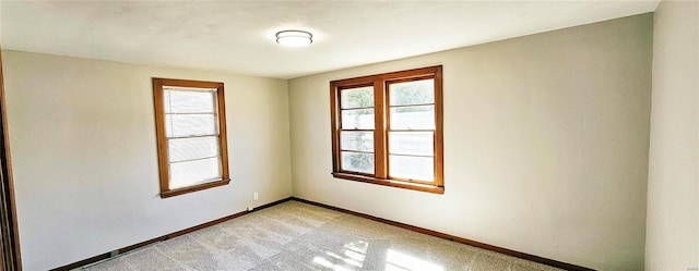 unfurnished room with light carpet, plenty of natural light, and baseboards