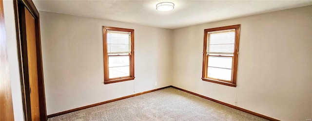 carpeted empty room with baseboards