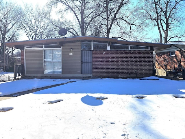 view of snow covered back of property