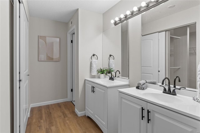 bathroom featuring hardwood / wood-style flooring, vanity, and a textured ceiling