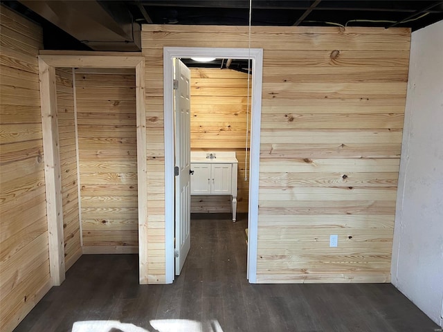 hall featuring dark wood-type flooring and wooden walls