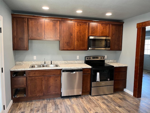 kitchen featuring appliances with stainless steel finishes, sink, and hardwood / wood-style floors